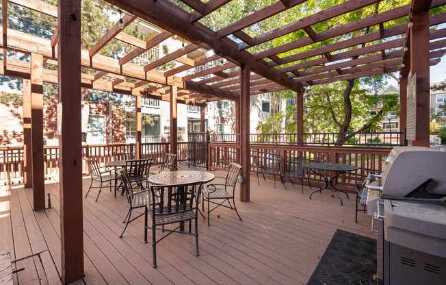 a patio with tables and chairs and a wooden deck