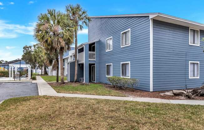 a blue building with palm trees in front of it