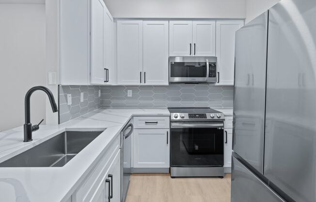 a kitchen with white cabinets and stainless steel appliances