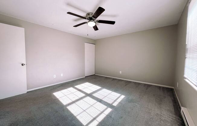 an empty room with a ceiling fan in it