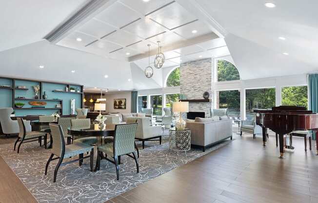 A spacious clubhouse with a grand piano and a dining table set up.