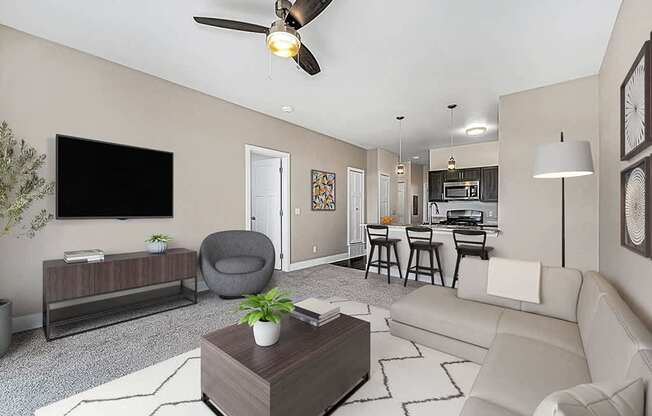 A living room with a grey armchair, a white sofa, a wooden coffee table, and a ceiling fan at Trade Winds Apartment Homes, Elkhorn, Nebraska