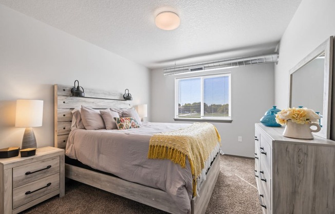 Bright, vacant bedroom with neutral walls and carpet flooring.