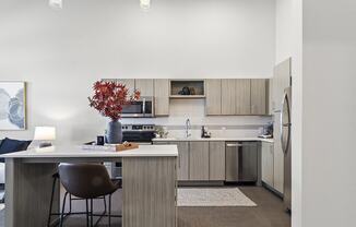 a kitchen with wooden cabinets and a table with a chair