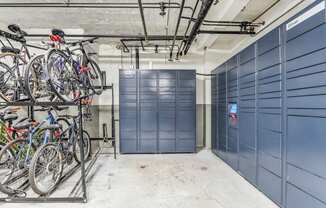 A bike rack with several bicycles is in front of a wall of blue lockers.
