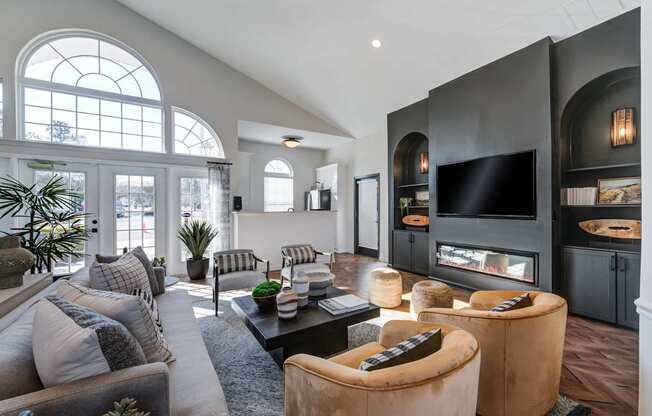 A modern living room with a grey sofa, a black coffee table, and a large window.