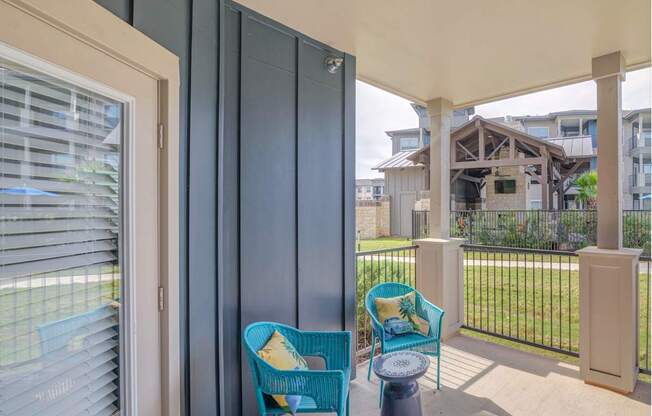 A balcony with a blue chair and a table.