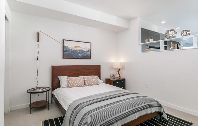 a bedroom with a bed and a black and white rug