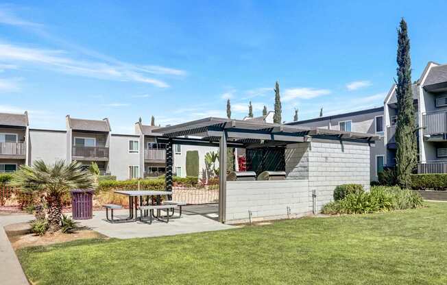A sunny day at a residential area with apartment buildings and a picnic table.