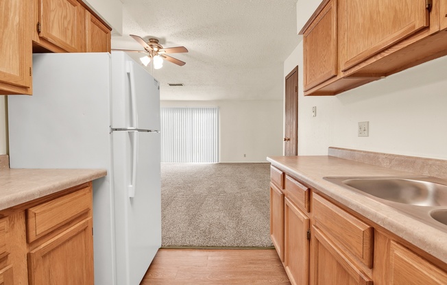 A kitchen with wooden cabinets and a white refrigerator.