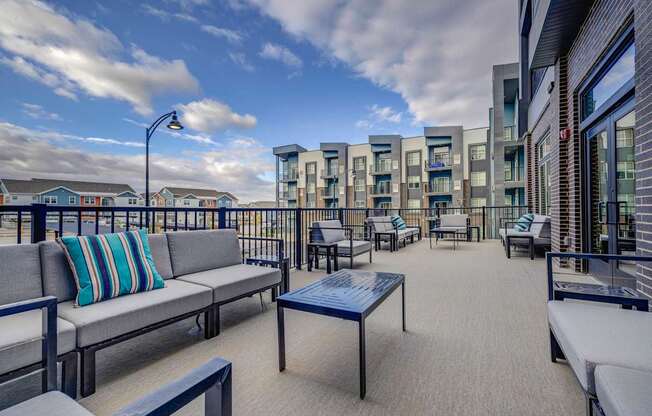 a balcony with couches and chairs and a view of the ocean