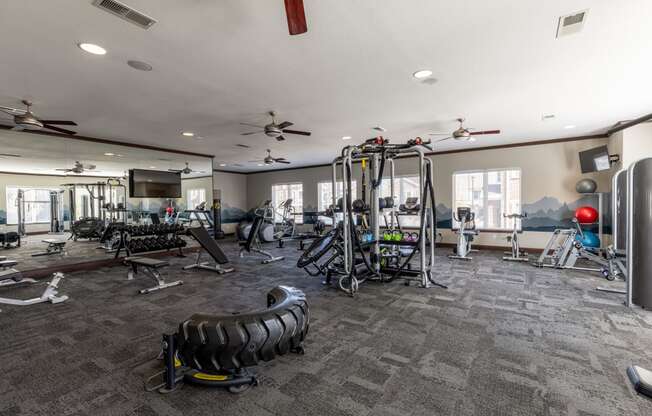 spacious gym with cardio machines and weights at the enclave at woodbridge apartments