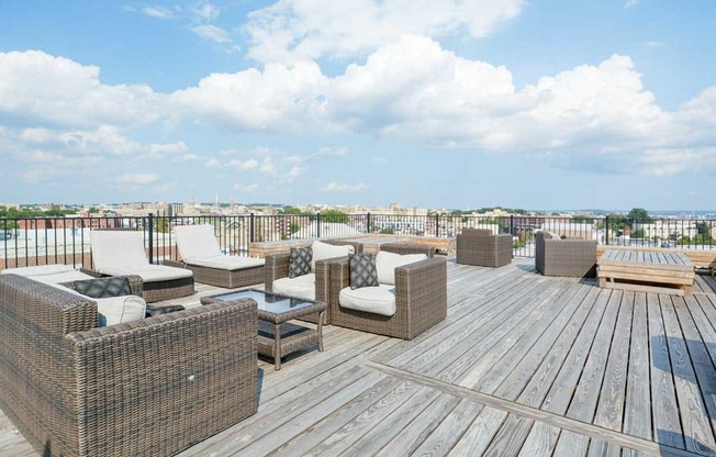 a rooftop deck with lounge chairs and a fire pit