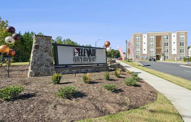 A sign for a Heights Riverview apartment complex is in front of a building.