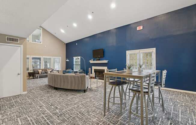 Clubhouse lounge area with couch and a TV above the fireplace at Woodmere Trace apartments in Duluth, GA