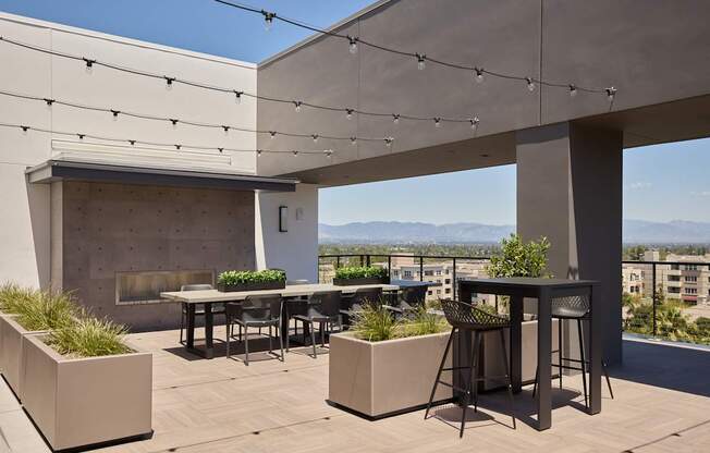 A patio with a table and chairs overlooking a cityscape.
