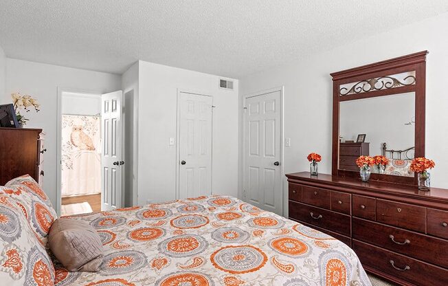 a bedroom with a bed and a dresser and a mirror