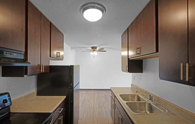 a kitchen with dark cabinets and a ceiling fan