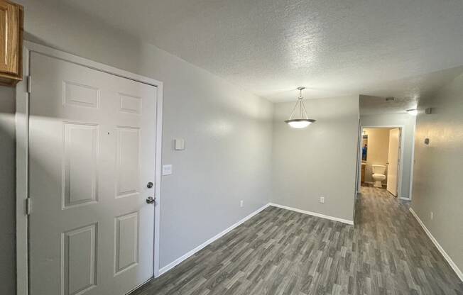 A room with a white door and a grey floor.