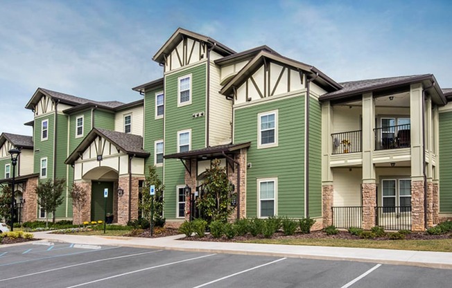 an exterior view of an apartment building with a parking lot