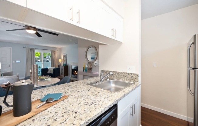 a kitchen with granite counter tops and a stainless steel sink