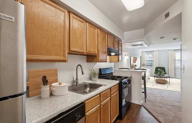 A kitchen with wooden cabinets and a stainless steel refrigerator.