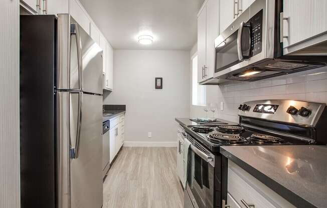 A modern kitchen with stainless steel appliances and white cabinets.