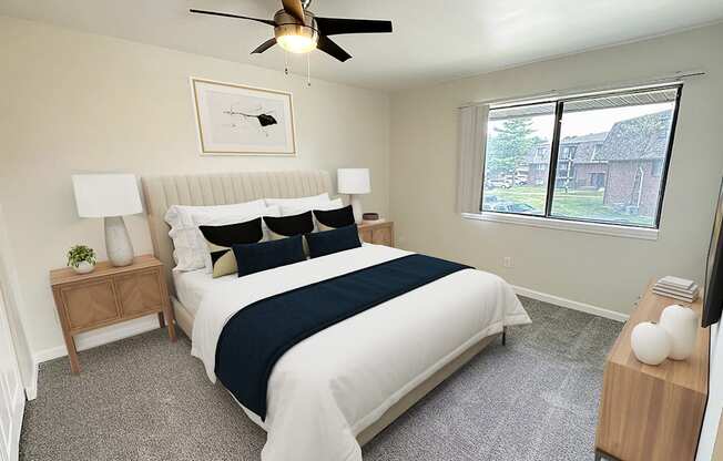 A bedroom with a bed, nightstand, and window.