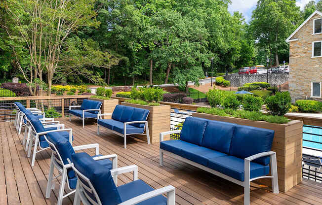 A wooden deck with blue cushioned chairs and a bench. at Mill House at East Cobb, Georgia ,30067