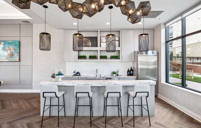 A modern kitchen with a white marble island and bar stools.