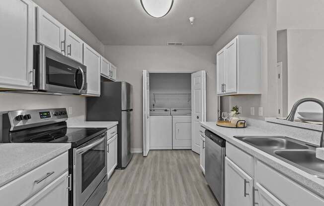A modern kitchen with white cabinets and stainless steel appliances.