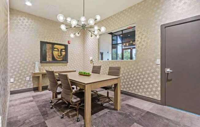 A conference room with a table, chairs, and a painting on the wall.