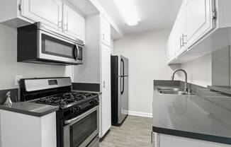 a kitchen with stainless steel appliances and white cabinets