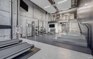 the lobby of a gym with stairs and a tv