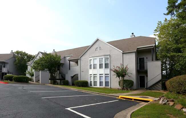 the exterior of an apartment building with a parking lot