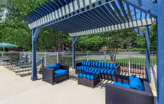 Shaded patio seating area with outdoor furniture at Ashley Oaks Apartments in Greensboro, NC