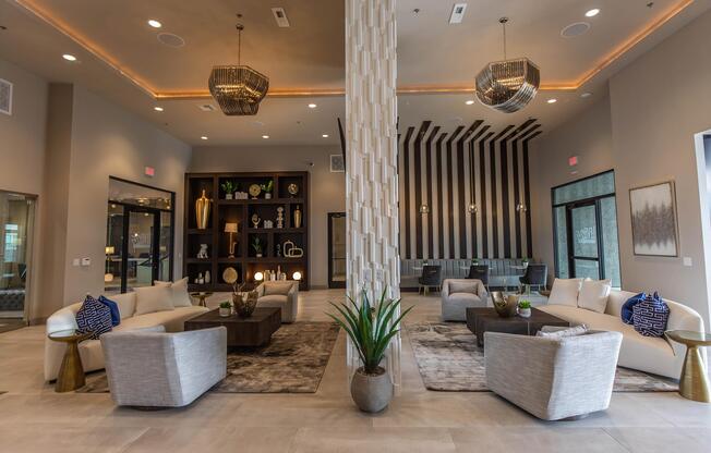 A modern lobby area featuring stylish seating arrangements, decorative plants, and contemporary lighting fixtures. The walls are adorned with geometric patterns and elegant decor items, creating a welcoming and sophisticated atmosphere. Bright and airy with large windows letting in natural light.