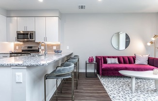 A modern kitchen with a pink couch and a marble countertop.