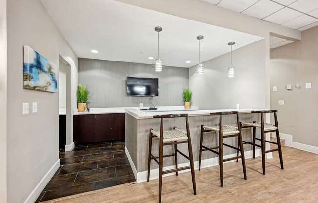 A bar area with a TV and two chairs.