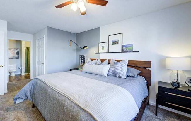 A bedroom with a large bed and a ceiling fan.