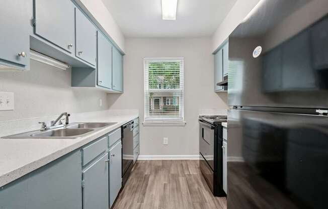 A kitchen with a sink, stove, and cabinets.