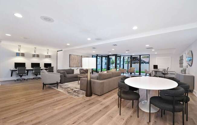 A modern living room with a white table and black chairs.