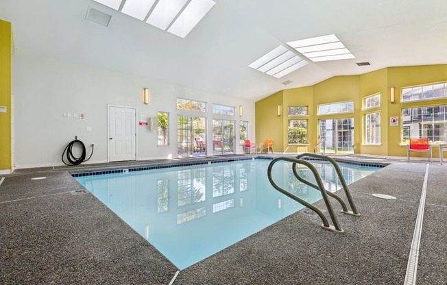 A large indoor swimming pool with a diving board.