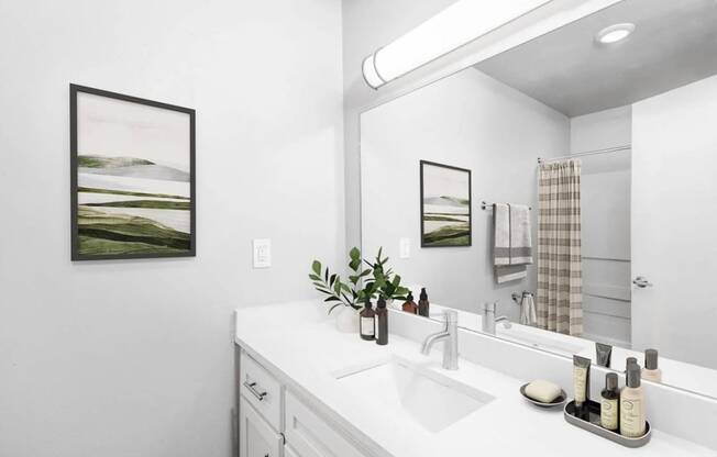 a white bathroom with a large mirror and a sink