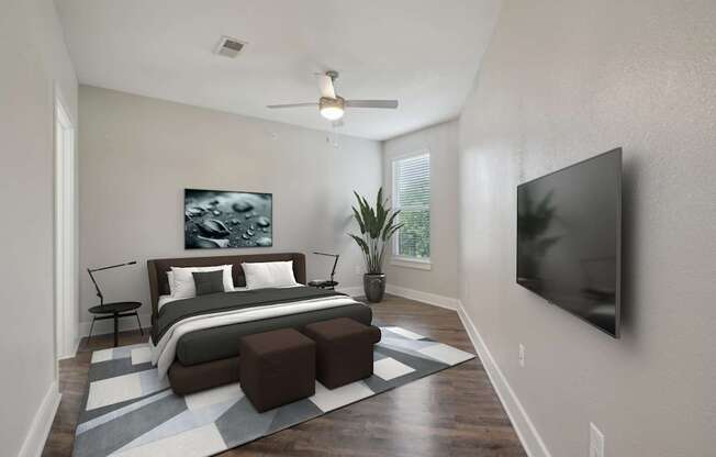 A modern bedroom with a large bed and a flat screen TV mounted on the wall.