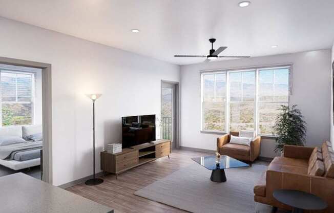 A modern living room with a television, a couch, a chair, and a potted plant at Refinery at Pointe17 Apartments, Phoenix, AZ