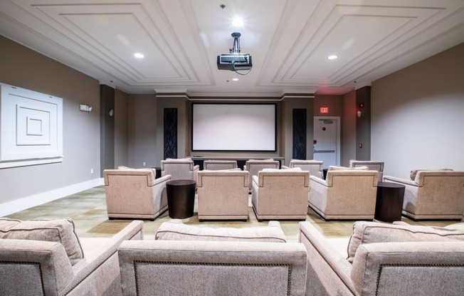 movie room with rows of chairs and a projector screen in the front of a room