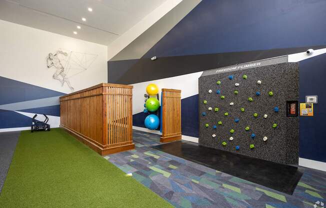 A room with a climbing wall and a wooden podium.