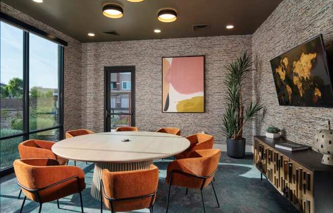 a meeting room with a round table and orange chairs at Zaterra Luxury Apartments, Chandler, AZ, 85286