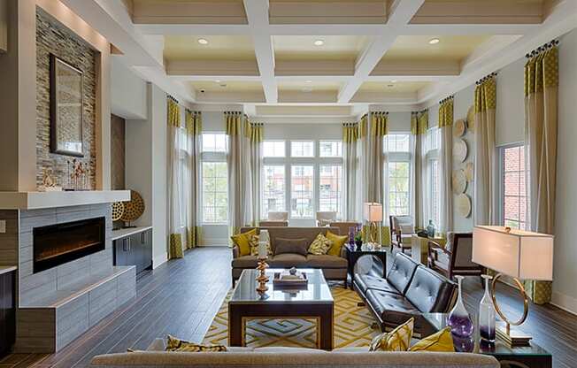 Clubhouse with chairs and fireplace; windows overlooking the pool